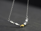 Swimming against the current. Dainty silver necklace. School of fish with one golden enameled fish swimming upstream. Gift for her.