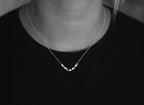Swimming against the current. Dainty silver necklace. School of fish with one golden enameled fish swimming upstream. Gift for her.
