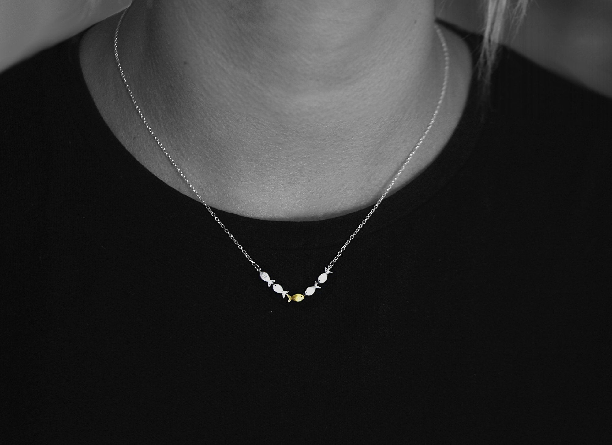 Swimming against the current. Dainty silver necklace. School of fish with one golden enameled fish swimming upstream. Gift for her.