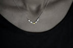 Swimming against the current. Dainty silver necklace. School of fish with one golden enameled fish swimming upstream. Gift for her.
